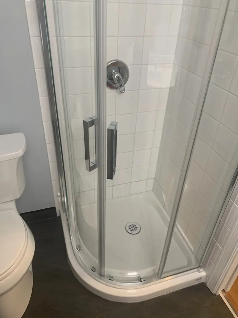 Corner shower with new pan and semi-frameless doors, lower bathroom renovation in Surrey