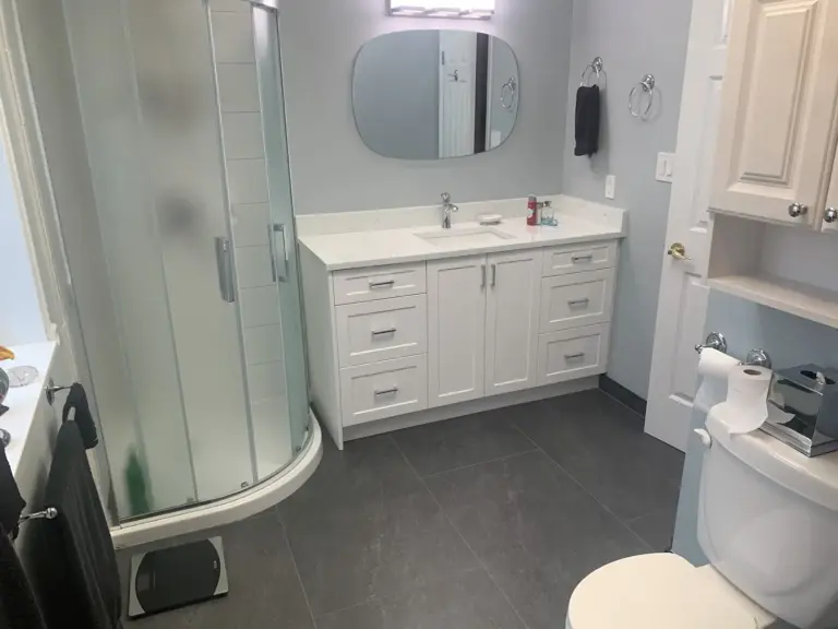 Renovated bathroom with corner shower, vanity and large-format floor tile in Surrey