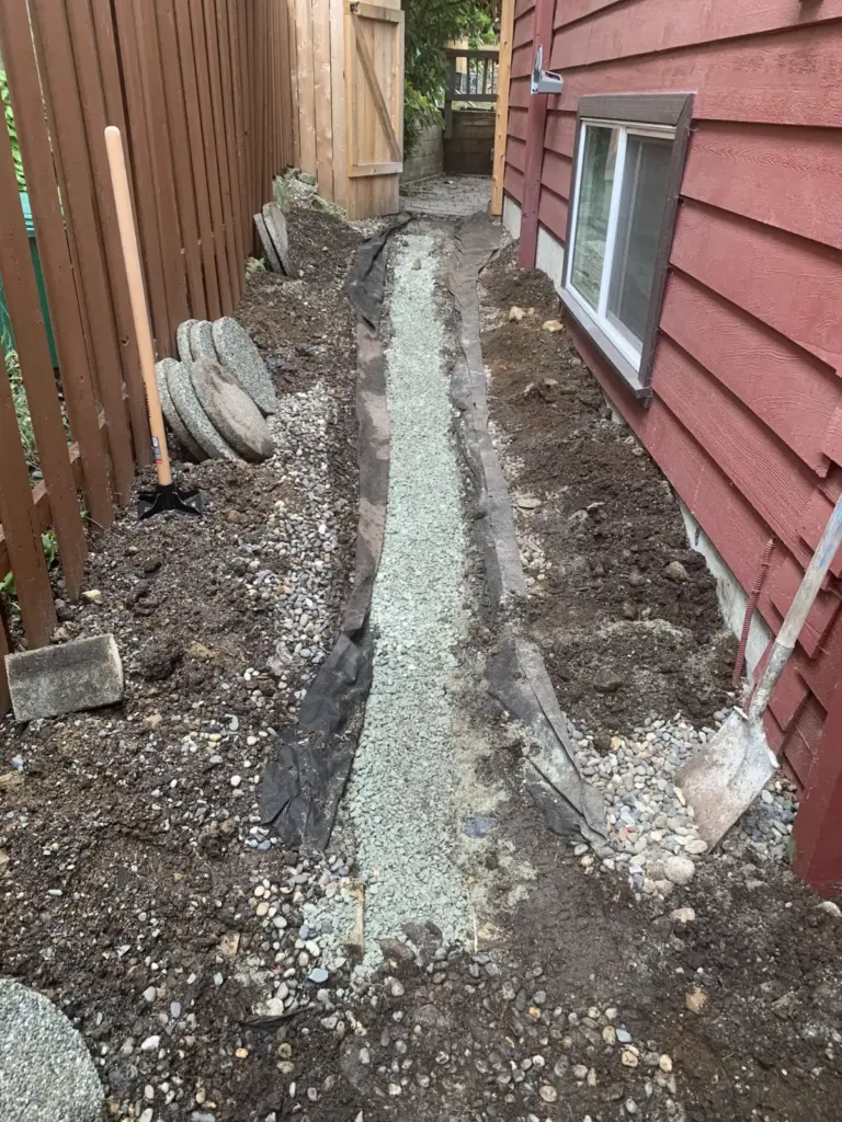 Side walkway with landscape fabric and compacted gravel base