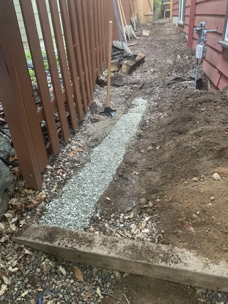 Gravel base laid along the side of the house