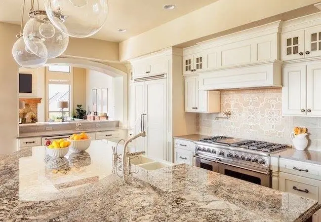 Kitchen with cream shaker cabinetry and a large stone island