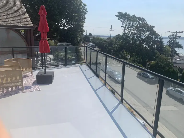 Resurfaced patio deck with glass railing and water view, deck resurfacing in White Rock