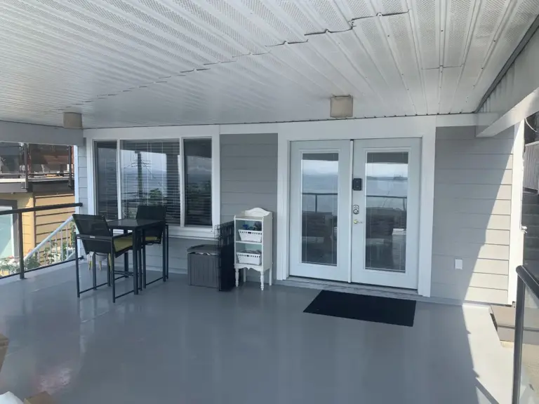 Covered lower patio with resurfaced floor and new siding, exterior renovation in White Rock